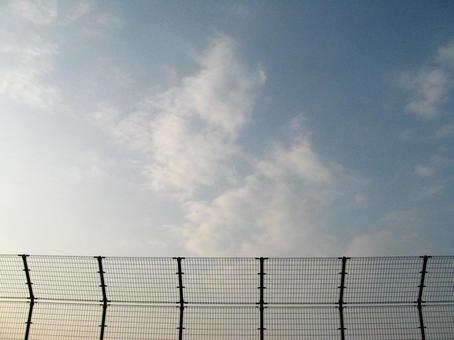 フェンス越しに広がる空 フェンス越しに広がる空の写真