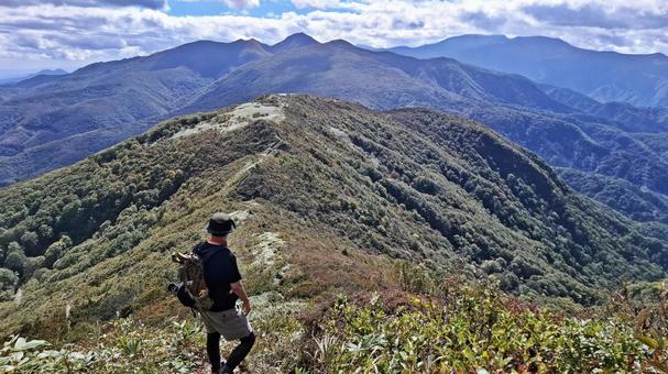 山頂からの景色を眺める登山者 山頂からの景色を眺める登山者 登山,縦走,登山者の写真素材