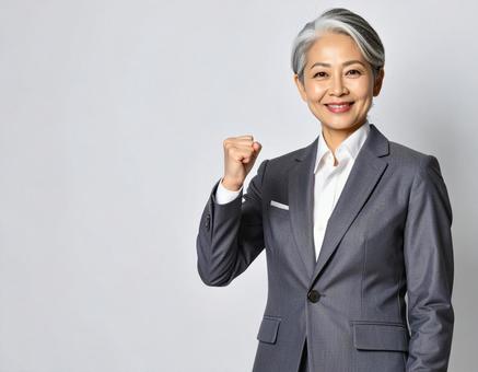 ガッツポーズをするスーツの白髪の女性 ガッツポーズをするスーツの白髪の女性の写真