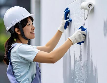 DIYで外壁塗装する女性 DIYで外壁塗装する女性の写真