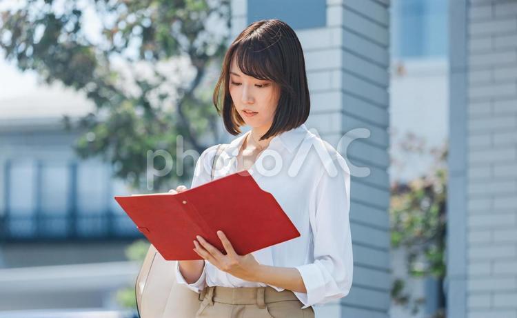 屋外で手帳をチェックするビジネスウーマン 女性,ビジネス,ビジネスウーマンの写真素材