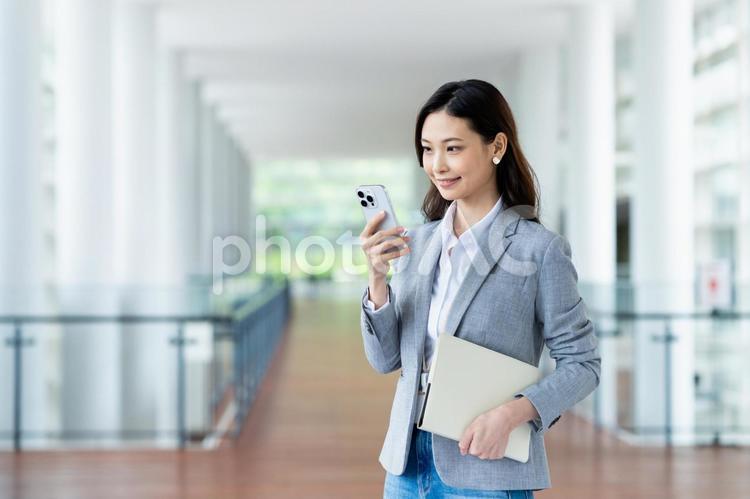 オフィスで働くビジネスウーマン スマートフォン,ビジネスウーマン,ビジネスの写真素材