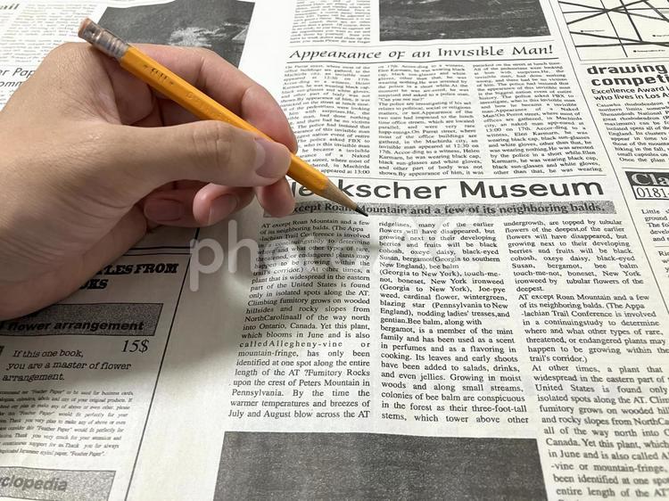 左手で英字新聞をなぞるイメージ 英字新聞,英語新聞,えんぴつの写真素材