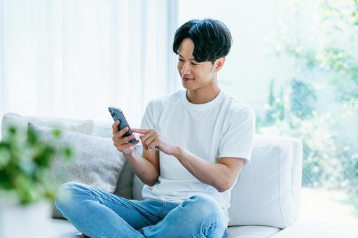 スマホを操作する男性 スマホを操作する男性 スマホ,笑顔,男性の写真素材