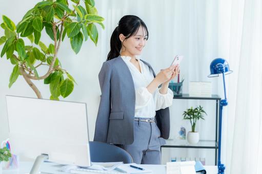 スマホを操作するビジネスウーマン ビジネスウーマン,スマホ,笑顔の写真素材