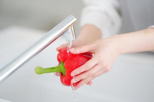赤いパプリカを洗う手 赤いパプリカを洗う手の写真