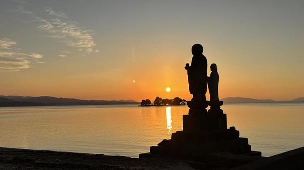 宍道湖に沈む夕日と袖師地蔵のシルエット 夕焼け,夕陽,日の入りの写真素材