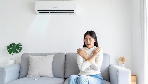 冷房が寒くて額に手をやる体調不良の女性 冷房が寒くて額に手をやる体調不良の女性の写真