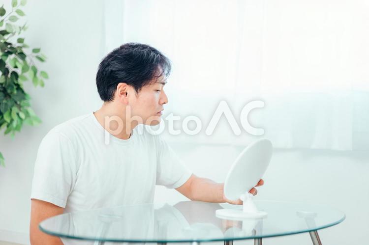 鏡を見て悩む男性 スキンケア,肌荒れ,トラブルの写真素材