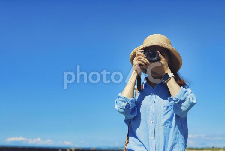 カメラで撮影する女性と青空 カメラ,一眼レフ,一眼レフカメラの写真素材