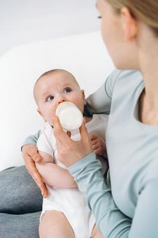 ミルクを飲みながら母親を見る赤ちゃん ミルクを飲みながら母親を見る赤ちゃん 赤ちゃん,哺乳瓶,飲むの写真素材