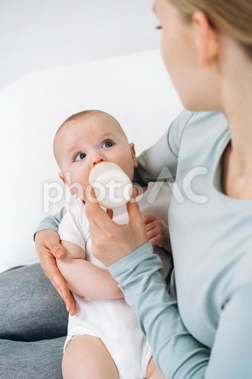 ミルクを飲みながら母親を見る赤ちゃん 赤ちゃん,哺乳瓶,飲むの写真素材