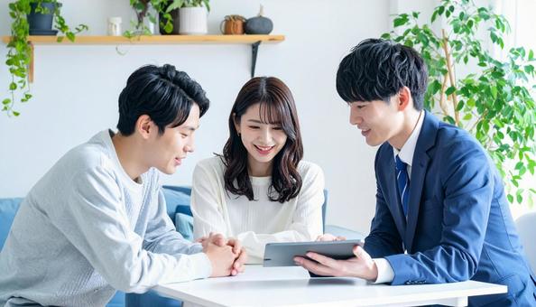 タブレットを使って説明する男性営業マン タブレットを使って説明する男性営業マンの写真
