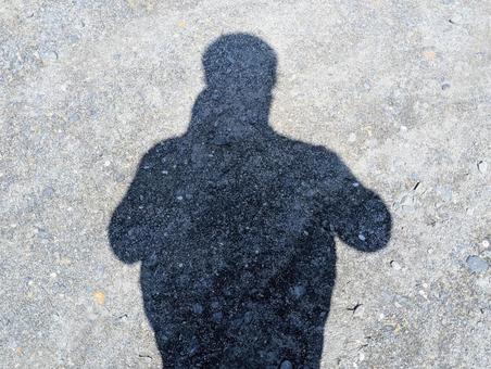 砂利道に落ちる人影 砂利道に落ちる人影の写真