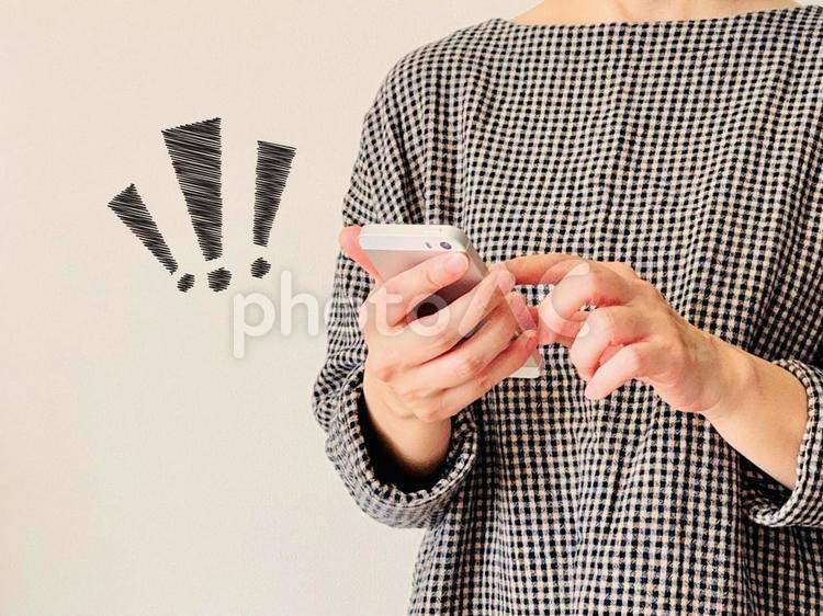 ショックを受けるスマホを操作する女性 びっくりマーク,女性,スマホの写真素材