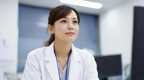 診察室に座る女性医師 診察室に座る女性医師の写真