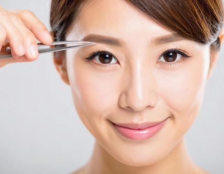 眉を整える女性 眉を整える女性の写真