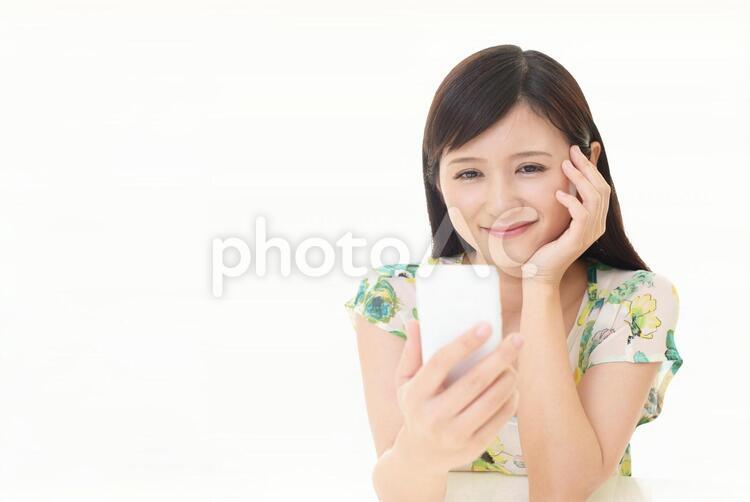 スマートフォンを持つ笑顔の女性 女性,スマートフォン,女の写真素材