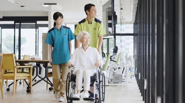 車椅子で散歩をする高齢者と介護士 車椅子で散歩をする高齢者と介護士 高齢者,車椅子,介護士の写真素材