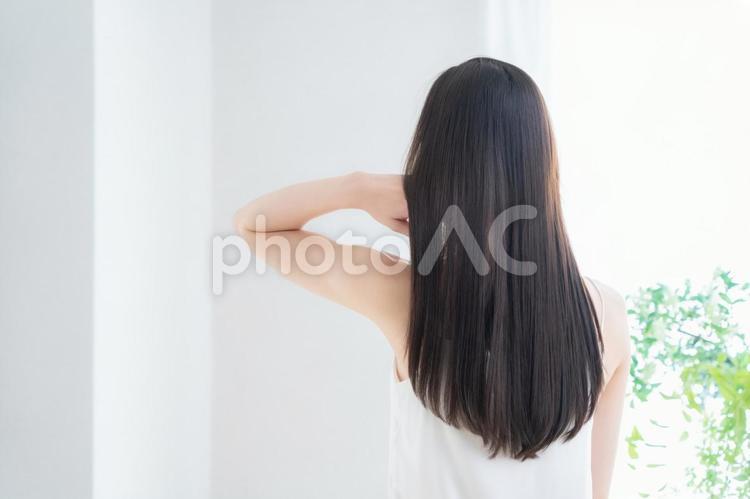 緑の中でヘアケアをする若い女性 ヘアケア,ビューティー,育毛の写真素材