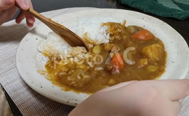 木のスプーンでカレーライスを食べる カレーライス,木のスプーン,手元の写真素材
