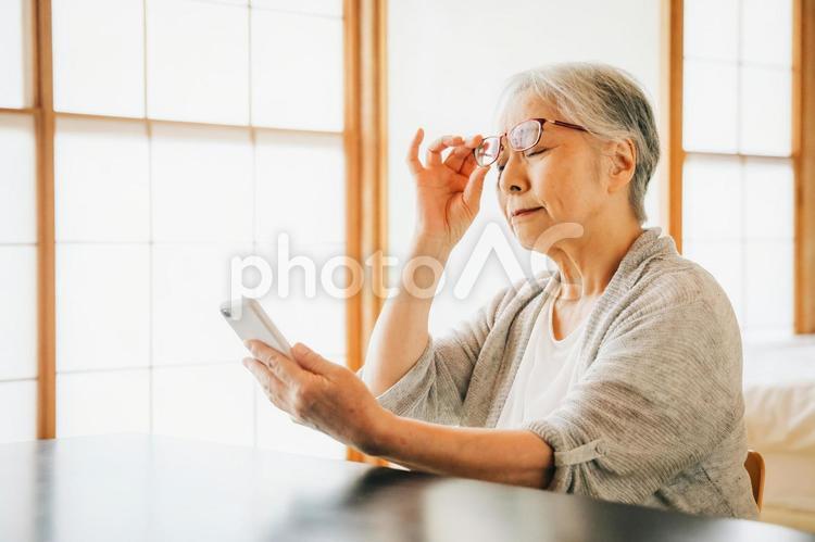 スマホを使う高齢者女性（老眼） 高齢者,老眼鏡,老眼の写真素材