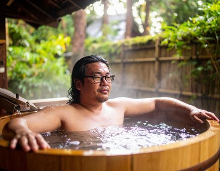露天風呂に浸かる男性 露天風呂に浸かる男性の写真