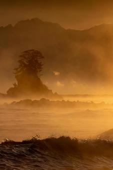 気嵐の海と手前の波_縦 逆光,コントラスト,シルエットの写真素材