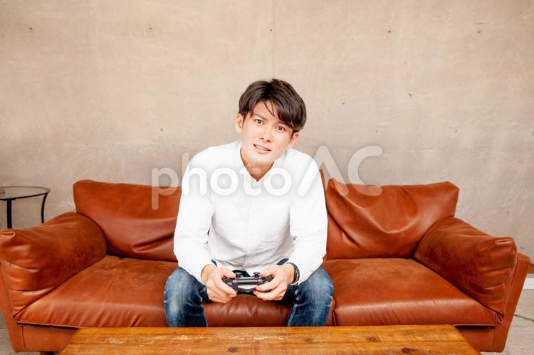 部屋でゲームをする男性 ゲーム,オンラインゲーム,テレビゲームの写真素材