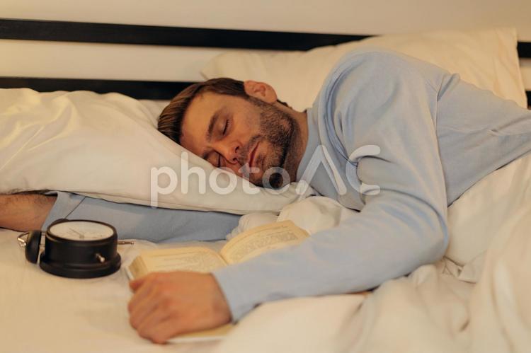 読書して寝落ちする男性 男性,ヒゲ,目を瞑るの写真素材