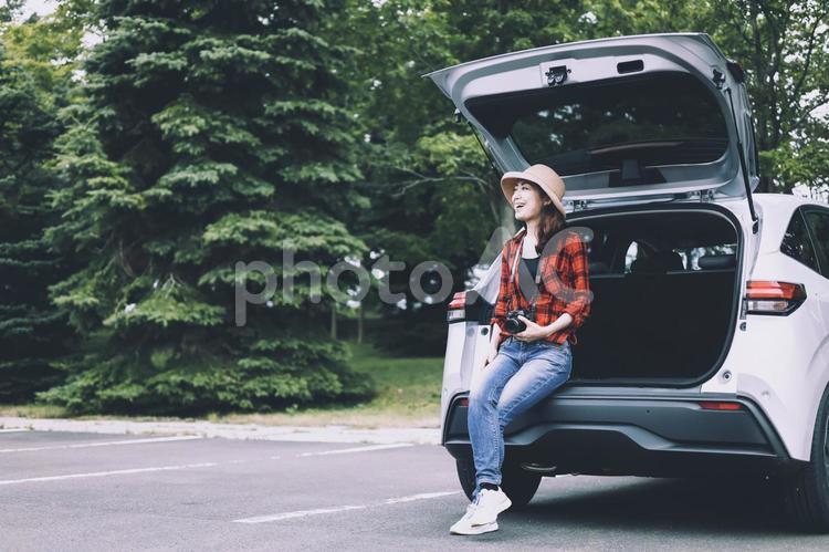 車とカメラを持つ女性 カメラ,一眼レフ,ドライブの写真素材