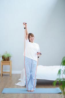 トレーニングチューブで筋トレ中の女性 女性,トレーニングチューブ,ゴムチューブの写真素材