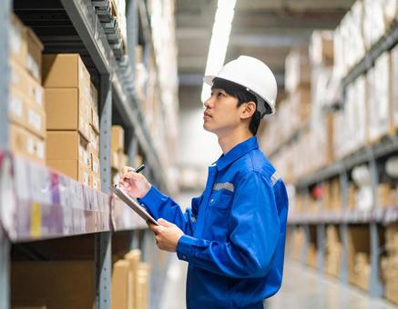 倉庫で在庫をチェックする男性作業員 倉庫で在庫をチェックする男性作業員の写真