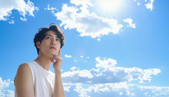 青空の背景に考える仕草の男性 青空の背景に考える仕草の男性の写真