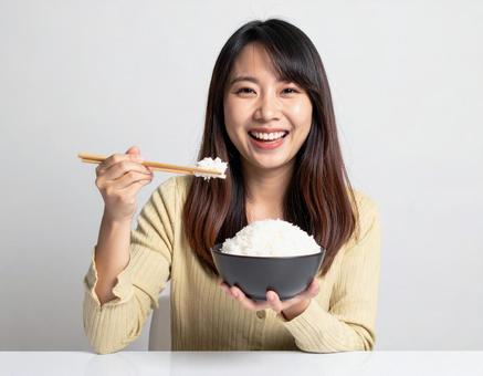 山盛りのごはん茶碗を持つ女性の写真