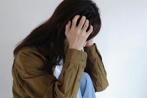 頭を抱える女性 頭を抱える女性 女性,頭を抱える,悩みの写真素材