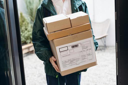 複数の段ボール箱の荷物を配達に来た男性 配達,フードデリバリー,デリバリーの写真素材