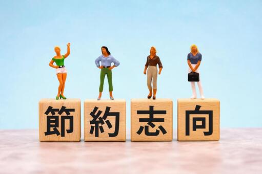 節約志向の文字ブロックと女性のミニチュア 節約志向,物価高,値上げの写真素材