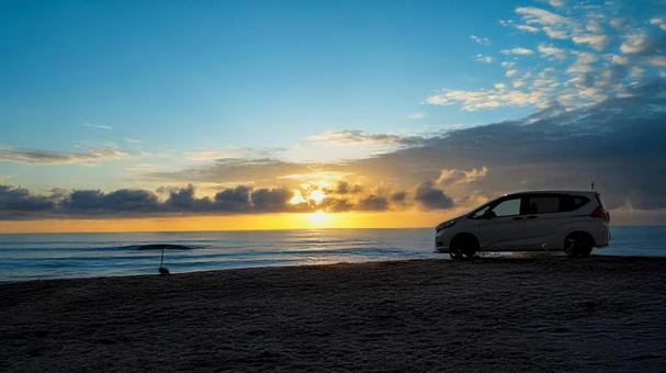 夕焼けの浜辺に留まっている車 夕焼けの浜辺に留まっている車の写真
