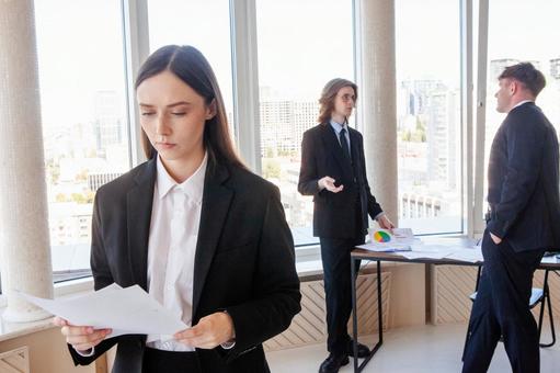 深刻な顔で書類を見るスーツの女性 男女,女性,資料の写真素材