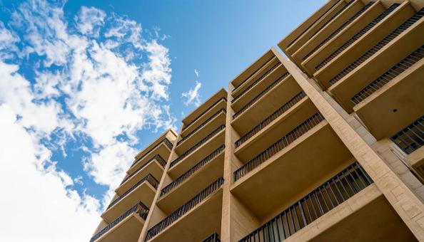 マンションを見上げる 青空背景 マンションを見上げる 青空背景の写真