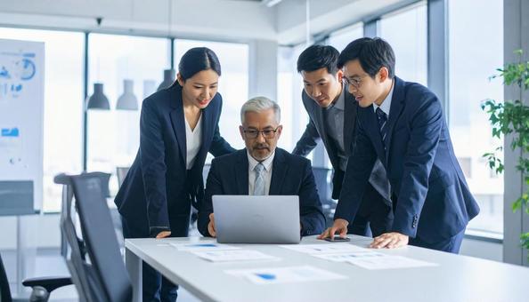 ビジネスマンがPCを囲んでミーティング ビジネスマンがPCを囲んでミーティングの写真