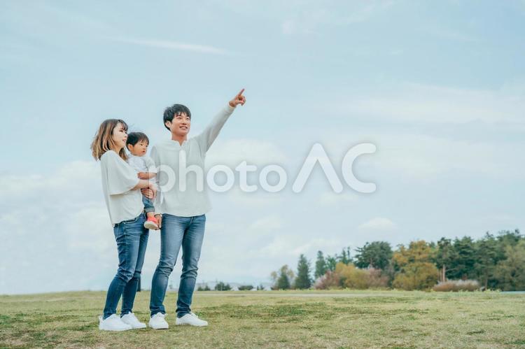 空と家族・ファミリー・赤ちゃん（全身・指差す） 家族,夫婦,赤ちゃんの写真素材