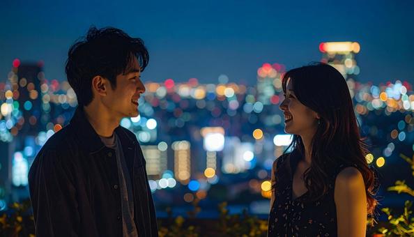 夜景の美しい都会の屋上庭園で談笑する男女 夜景の美しい都会の屋上庭園で談笑する男女の写真