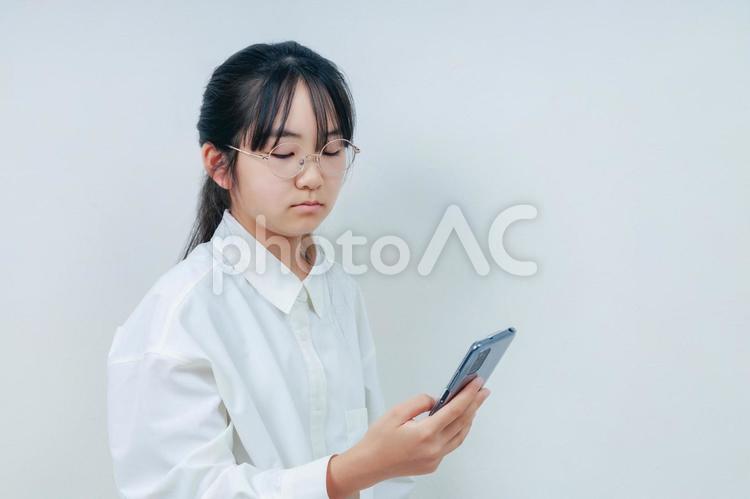 スマホを操作する眼鏡女子｜右スペース 女性,小学生,少女の写真素材