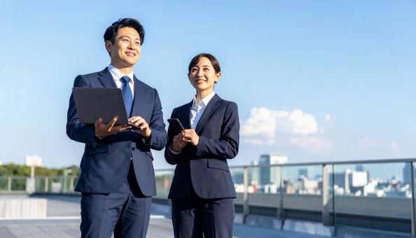 就職・転職 青空に立つスーツ姿の男女 就職・転職 青空に立つスーツ姿の男女 の写真