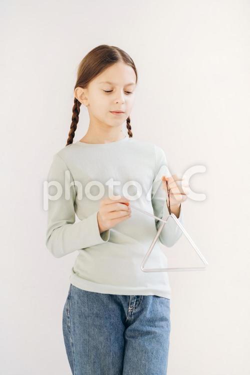 トライアングルを演奏するおさげの女の子 女の子,人物,ロングヘアの写真素材