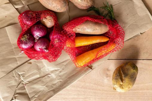 ネットに入ったニンジンなどの野菜 ネットに入ったニンジンなどの野菜の写真