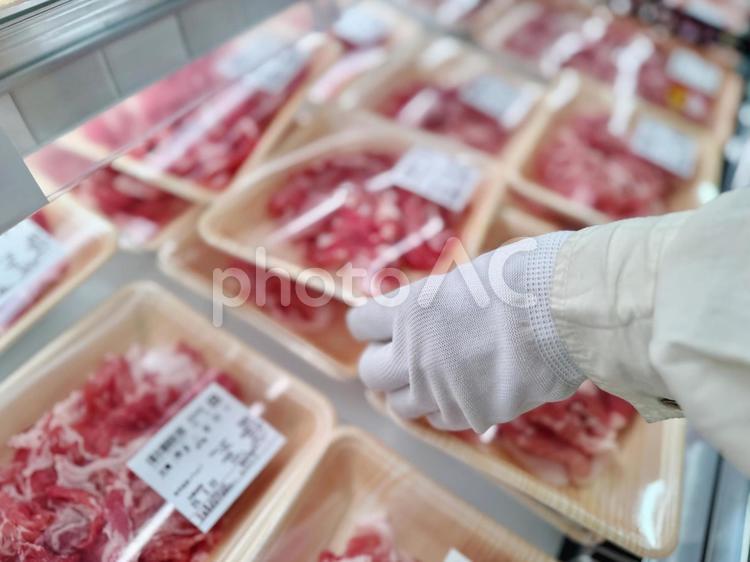 お肉のパックを白手袋をして手に取る女性 お肉,持つ,人物の写真素材