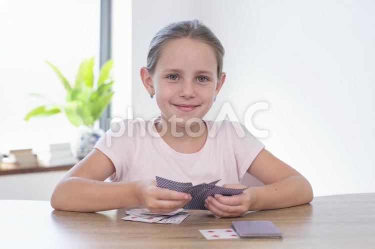 カメラ目線でトランプを広げている女の子 女の子,トランプ,ゲームの写真素材